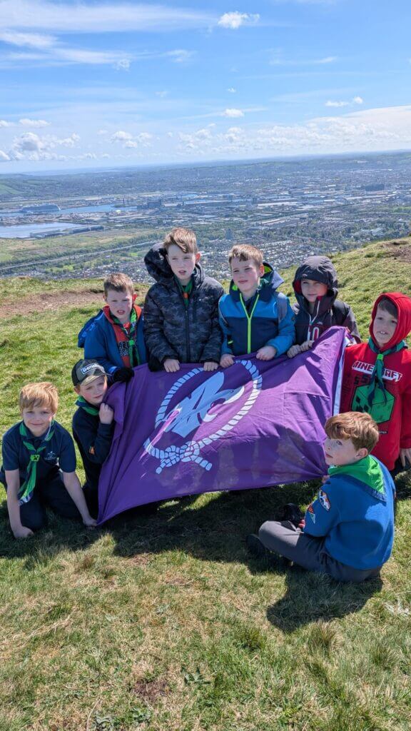 Cubs holding the flag at the top of cave hill