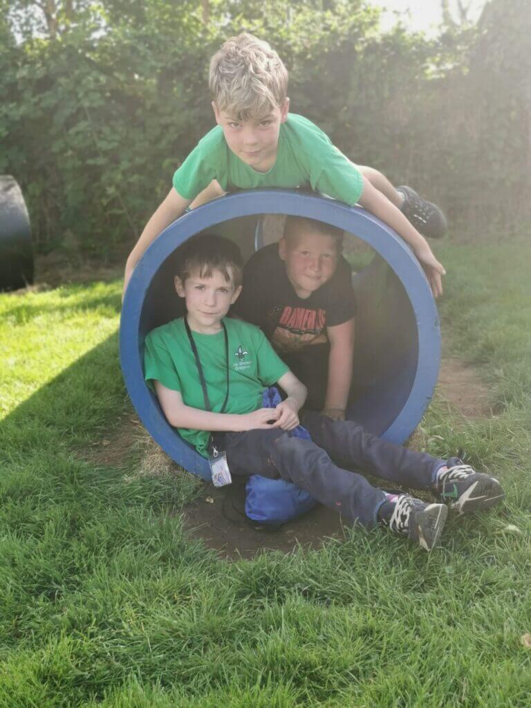 3 Cub Scouts on and inside a large tube